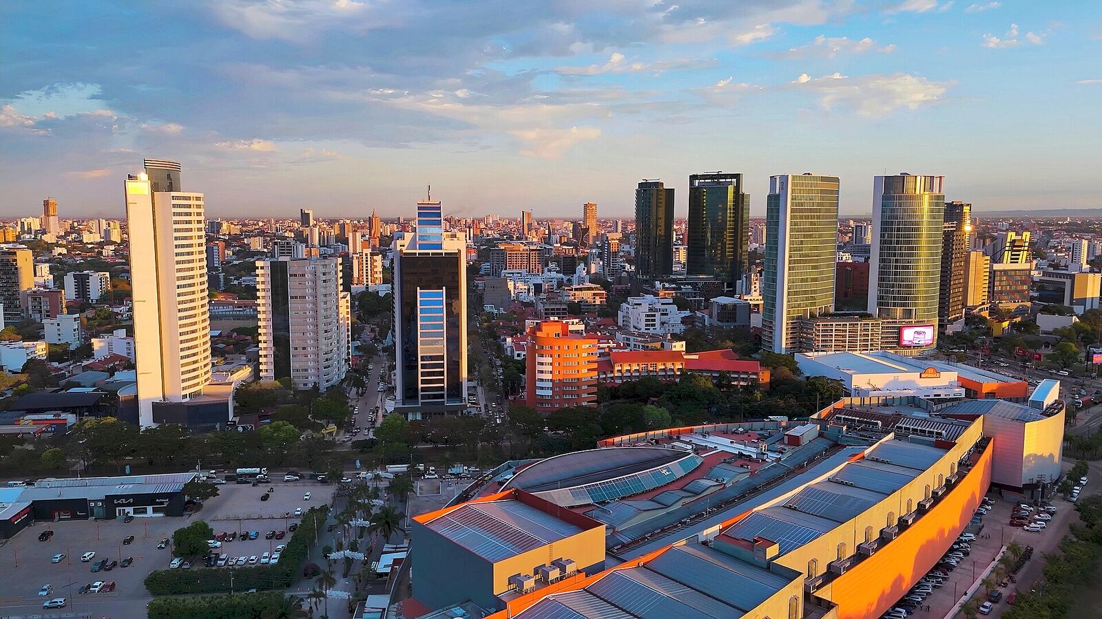 Torres de Equipetrol al atardecer, vistas desde el aire, con la ciudad extendiéndose hasta el horizonte