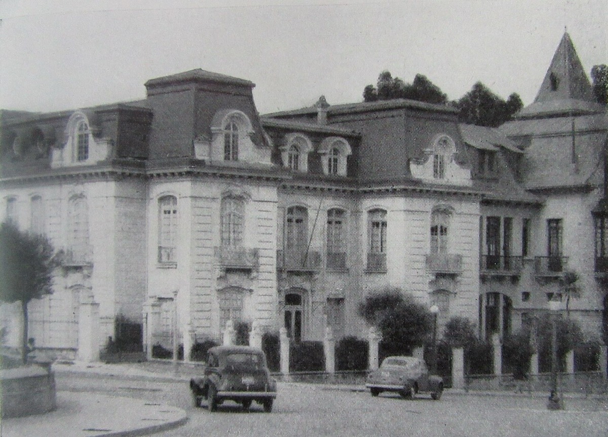 Fotografía en blanco y negro de una casa de dos plantas con mansardas en Sopocachi, 1948, con dos autos de la época